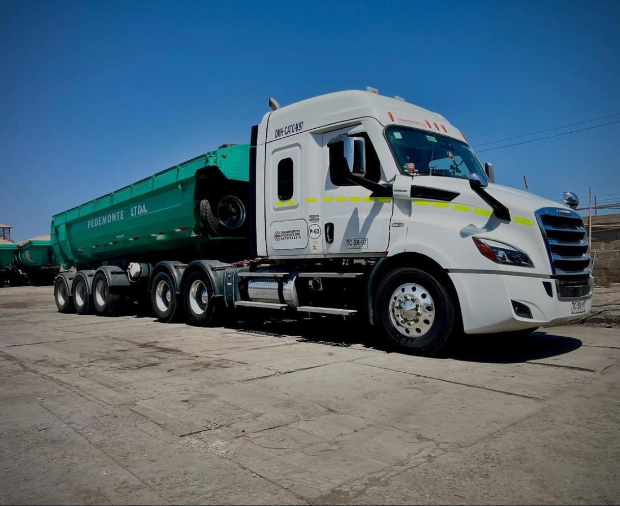 Tractocamión Freightliner blanco con batea verde Pedemonte Ltda.